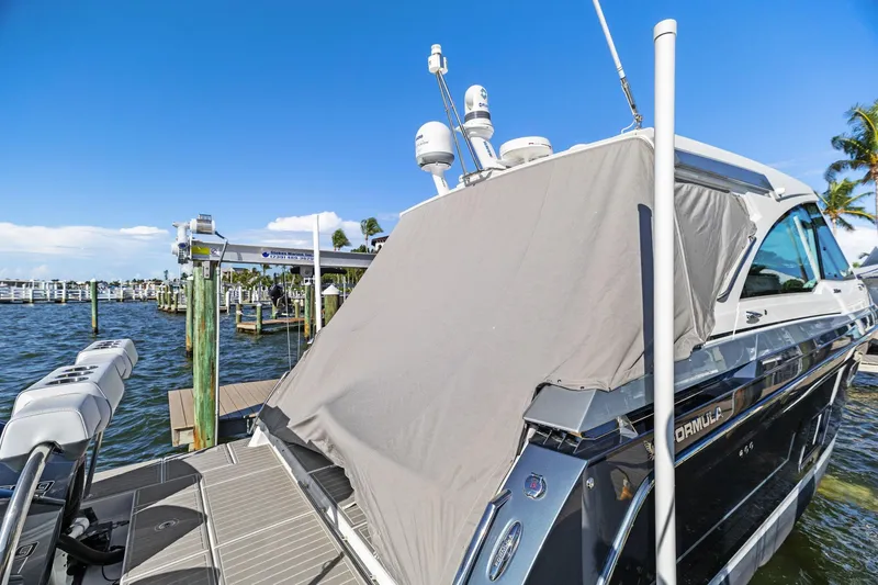 Slide: The Image of 2023 Formula 380 Super Sport Crossover OB docked, covered, with clear blue sky background. - 34