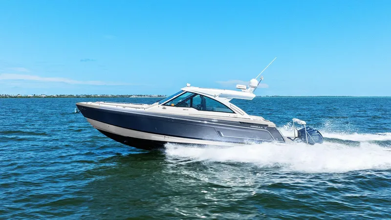 Slide: The Image of 2023 Formula 380 Super Sport Crossover OB cruising on open water under clear blue skies. - 37