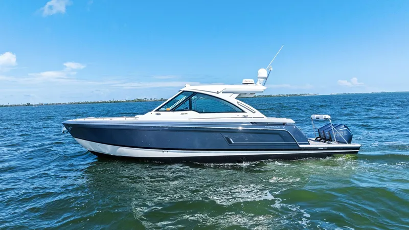 Slide: The Image of 2023 Formula 380 Super Sport Crossover OB cruising on open water under clear blue skies. - 4