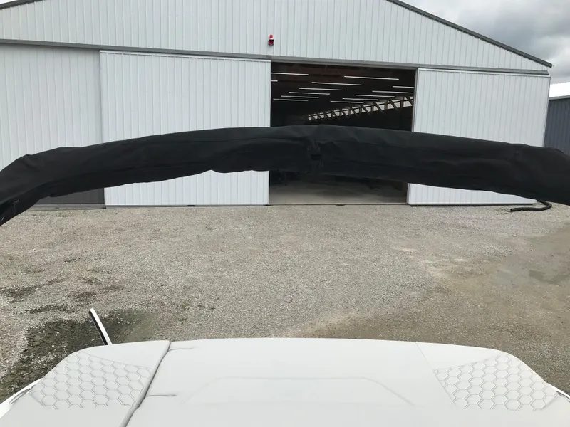 Slide: The Image of 2026 Four Winns H-1 FREEDOM boat near a large white storage building. - 20