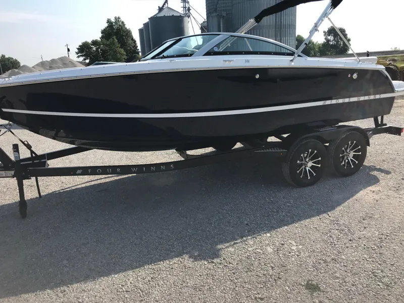 Slide: The Image of 2026 Four Winns H-1 FREEDOM boat on trailer, parked outdoors. - 24