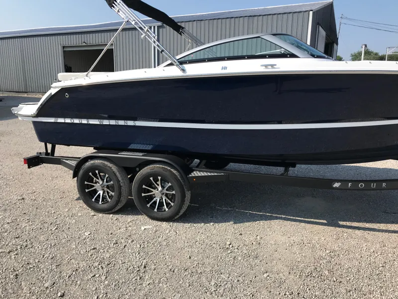 Slide: The Image of 2026 Four Winns H-1 FREEDOM boat on trailer, parked outdoors. - 26