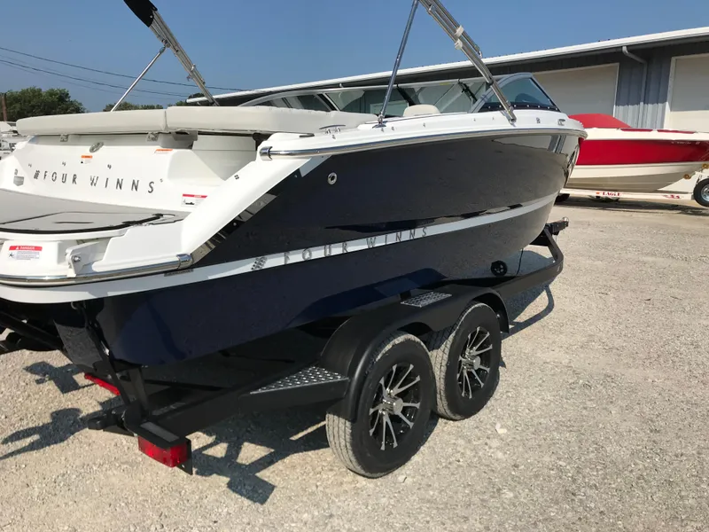 Slide: The Image of 2026 Four Winns H-1 FREEDOM boat on a trailer, parked outdoors. - 27