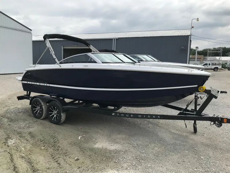 Slide: The Image of 2026 Four Winns H-1 FREEDOM boat on trailer, parked outdoors. - 4