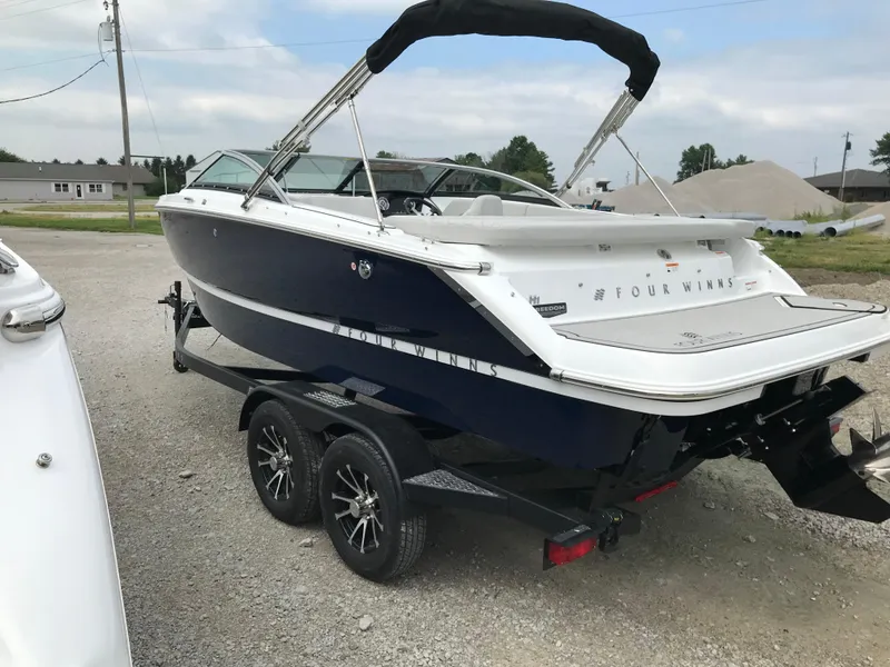 Slide: The Image of 2026 Four Winns H-1 FREEDOM boat on trailer, parked outdoors. - 5