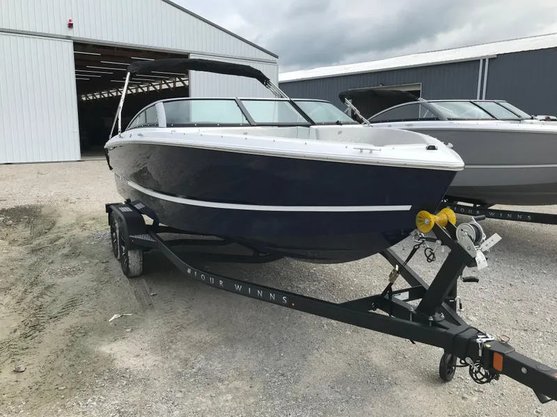 Slide: The Image of 2026 Four Winns H-1 FREEDOM boat on trailer outside storage facility. - 6