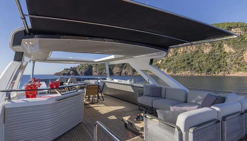 Slide: The Image of Luxurious 2026 Absolute NAVETTA 75 yacht deck with seating, bar, and scenic ocean view. - 10