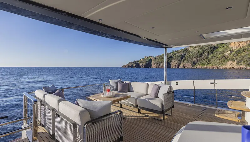 Slide: The Image of Luxury deck view on 2026 Absolute NAVETTA 75 yacht, overlooking serene ocean and coastal cliffs. - 13