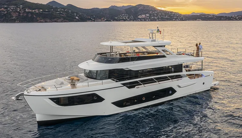 Slide: The Image of 2026 Absolute NAVETTA 75 yacht cruising at sunset with scenic mountain backdrop. - 2