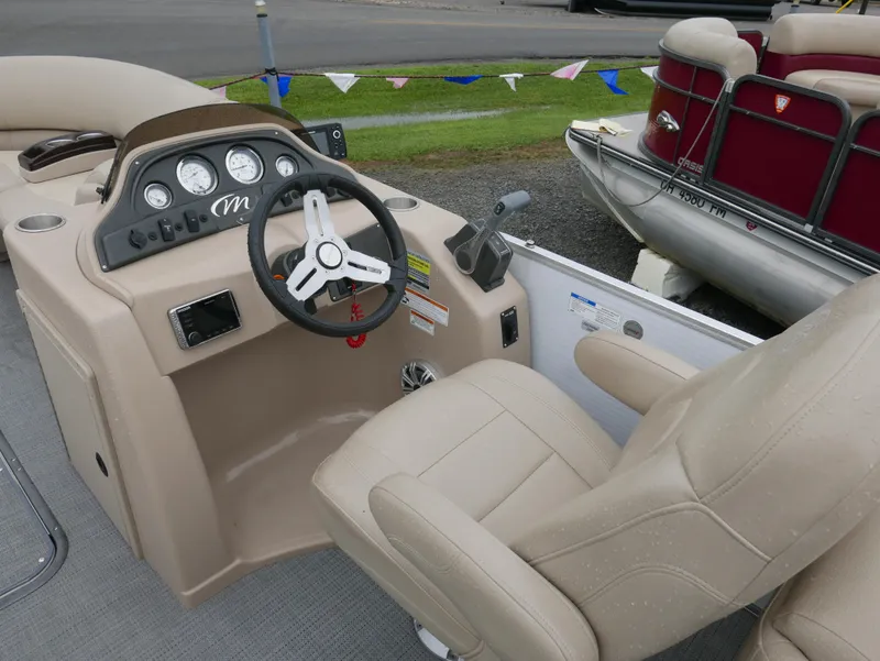 Slide: The Image of 2017 Manitou Aurora VP boat interior with steering wheel and beige seating. - 11