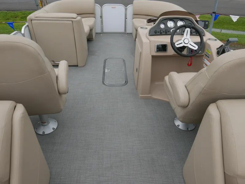 Slide: The Image of 2017 Manitou Aurora VP boat interior with beige seating and steering console. - 13