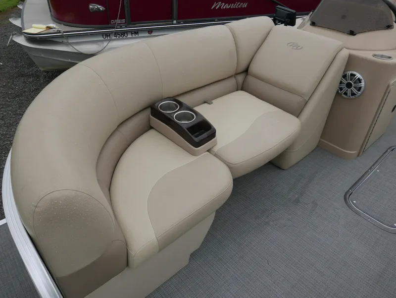 Slide: The Image of 2017 Manitou Aurora VP boat interior with beige seating and cup holders. - 8