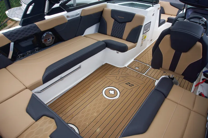 Slide: The Image of 2022 MasterCraft XT22 boat interior with tan and black seating, stylish flooring, and modern design. - 10