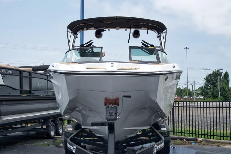 Slide: The Image of 2022 MasterCraft XT22 boat on trailer, front view, parked outdoors. - 5