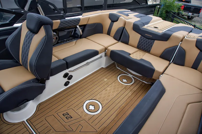 Slide: The Image of 2022 MasterCraft XT22 boat interior with luxurious tan and black seating. - 9