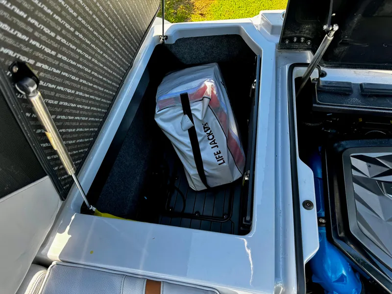 Slide: The Image of 2020 Nautique Super Air Nautique G25 storage compartment with life jackets. - 11