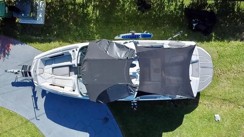 Slide: The Image of 2020 Nautique Super Air Nautique G25 Coastal Edition boat, aerial view with cover, on grass. - 3