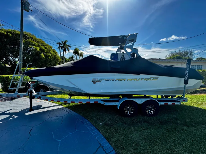 Slide: The Image of 2020 Nautique Super Air Nautique G25 Coastal Edition boat on trailer, covered, sunny day. - 30