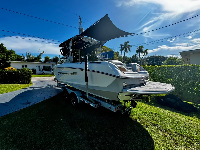 Slide: The Image of 2020 Nautique Super Air Nautique G25 Coastal Edition boat on trailer in sunny yard. - 6