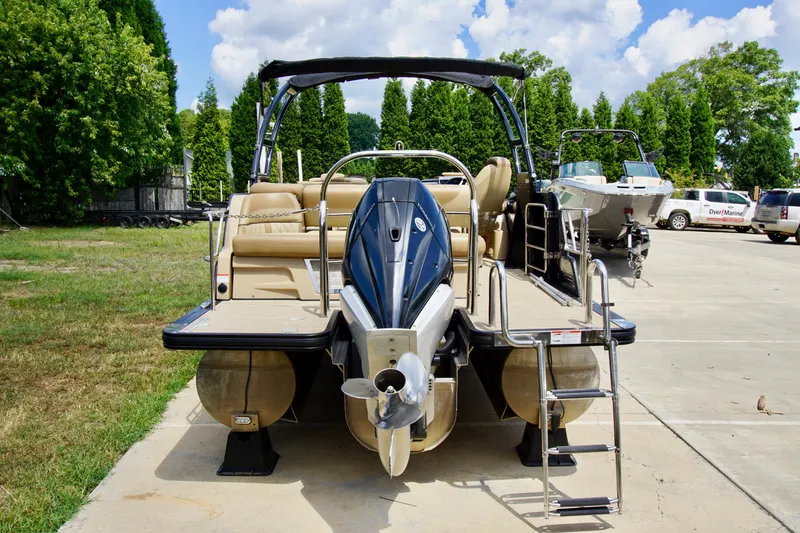 Slide: The Image of 2020 Harris Grand Mariner 230 pontoon boat with outboard motor, parked on concrete near trees. - 6