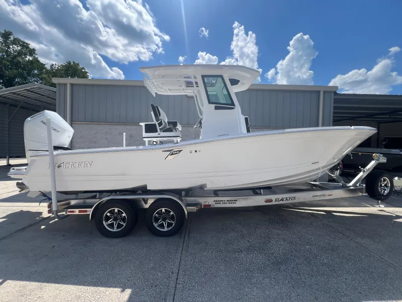 Slide: The Image of 2026 Blackfin 262 HB boat on trailer under a blue sky with clouds. - 2