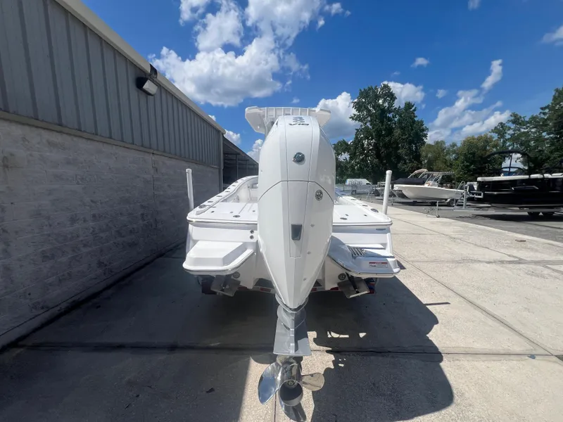 Slide: The Image of 2026 Blackfin 262 HB boat with powerful outboard motor, parked outdoors under a clear blue sky. - 4