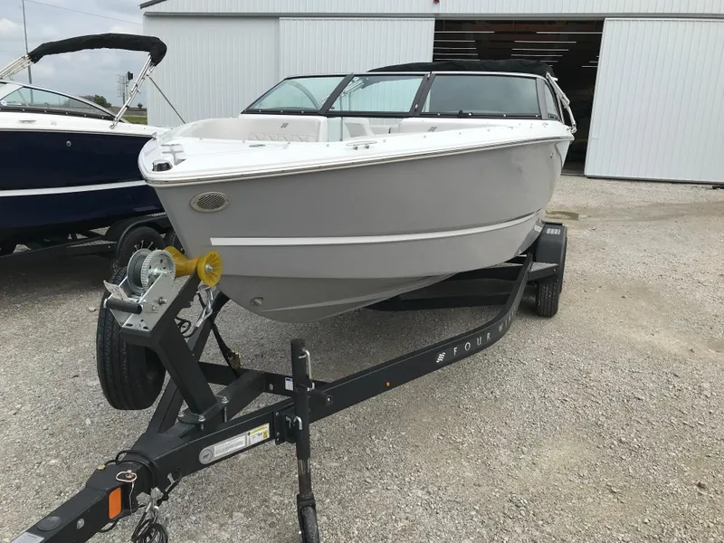 Slide: The Image of 2026 Four Winns H-2 FREEDOM boat on trailer, parked outdoors. - 10