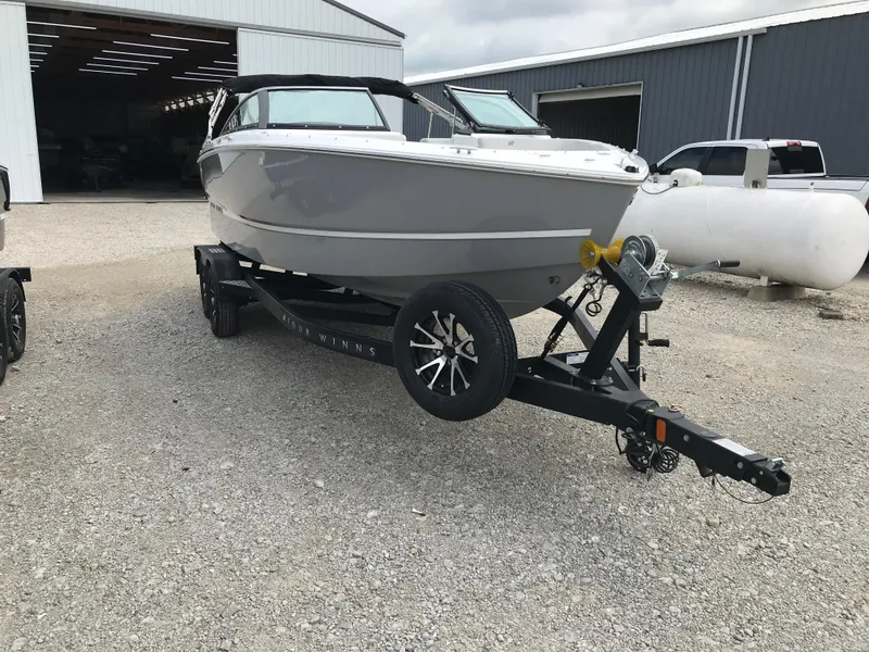 Slide: The Image of 2026 Four Winns H-2 FREEDOM boat on trailer outside a warehouse. - 13