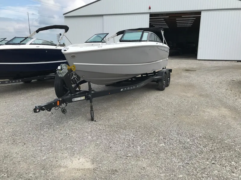 Slide: The Image of 2026 Four Winns H-2 FREEDOM boat on trailer outside a large garage. - 14