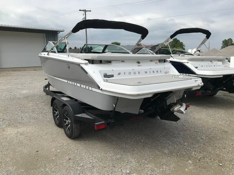 Slide: The Image of 2026 Four Winns H-2 FREEDOM boat on trailer, parked outdoors. - 9