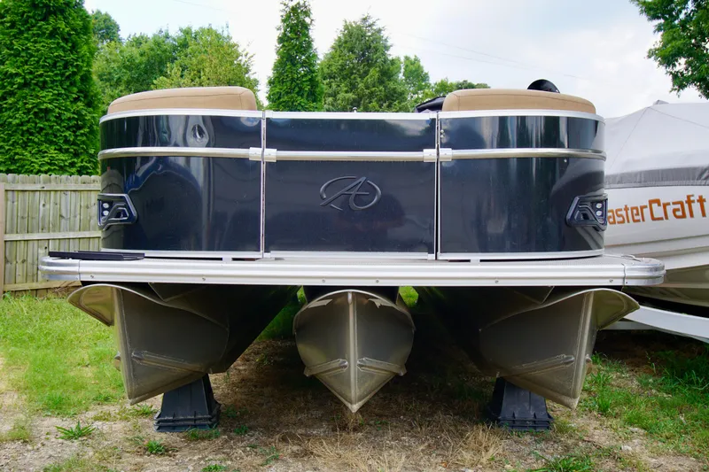Slide: The Image of 2020 Avalon Catalina Platinum Rear Lounger pontoon boat, parked on grass. - 2
