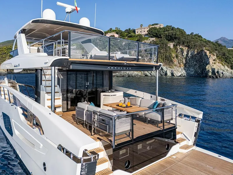Slide: The Image of Luxurious 2026 Absolute NAVETTA 70 yacht with spacious deck, scenic coastal backdrop. - 4