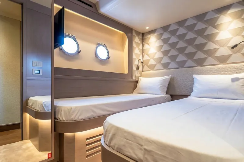 Slide: The Image of Luxurious cabin interior of 2026 Absolute NAVETTA 70 yacht with twin beds and portholes. - 70