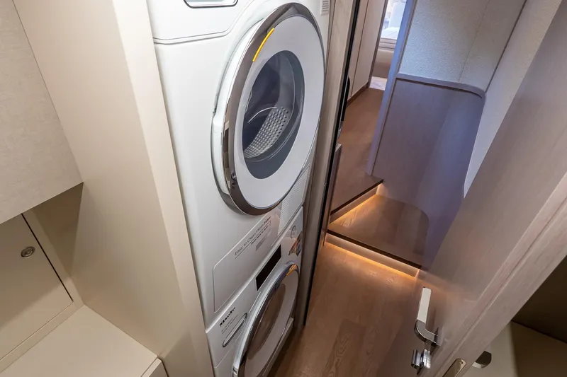 Slide: The Image of Laundry area inside Absolute NAVETTA 70 yacht, featuring stacked washer and dryer units. - 71