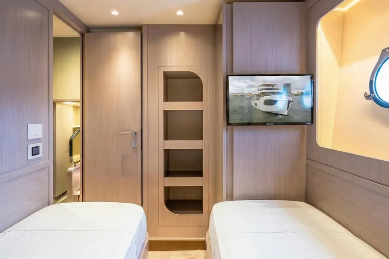 Slide: The Image of Interior of 2026 Absolute NAVETTA 70 yacht cabin with twin beds and TV. - 74