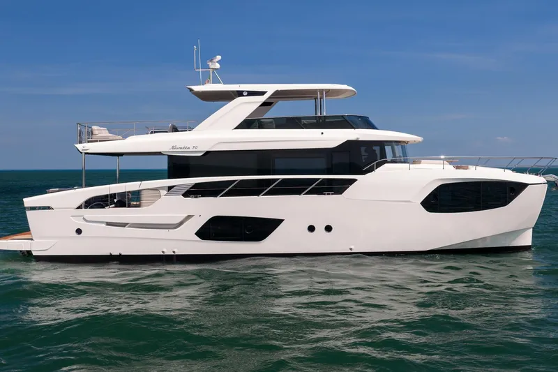 The Image of Luxurious 2027 Absolute Navetta 70 yacht cruising on open water under clear blue skies. - 0