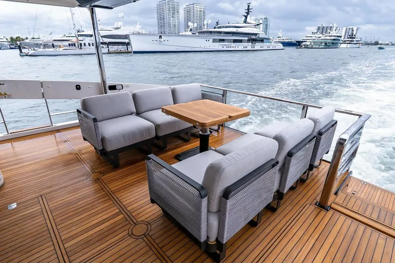 Slide: The Image of Luxurious 2026 Absolute NAVETTA 70 yacht deck with elegant seating and wooden table. - 11