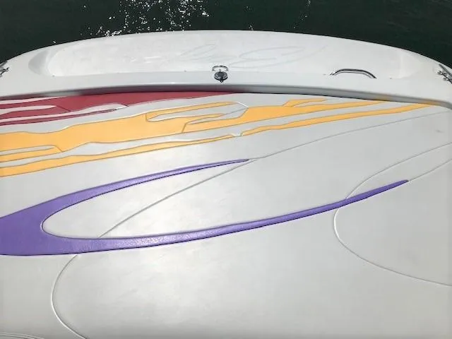 Slide: The Image of 2002 Baja 232 boat with colorful abstract graphics on deck. - 24