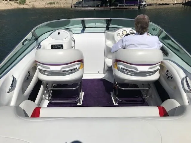 Slide: The Image of 2002 Baja 232 boat interior with two white seats and a person at the helm. - 31