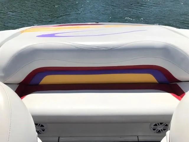 Slide: The Image of 2002 Baja 232 boat interior with colorful upholstery and water in the background. - 32