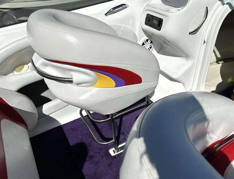 Slide: The Image of 2002 Baja 232 boat interior with colorful seat design and modern dashboard. - 37