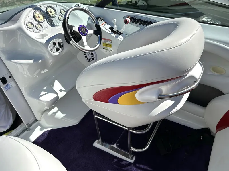 Slide: The Image of Interior of a 2002 Baja 232 boat with colorful seating and modern dashboard. - 42