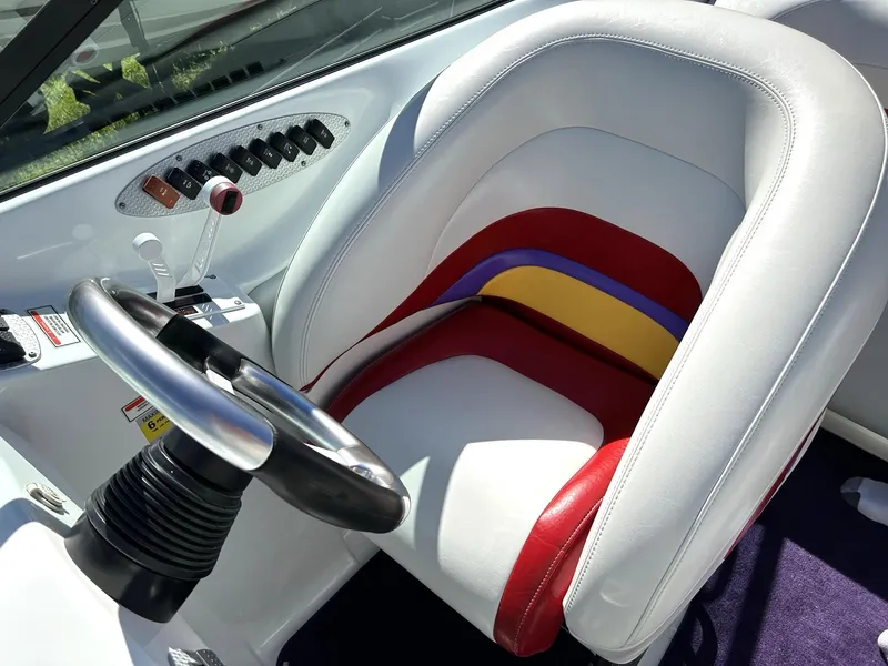 Slide: The Image of 2002 Baja 232 boat cockpit with colorful seat and steering wheel. - 43