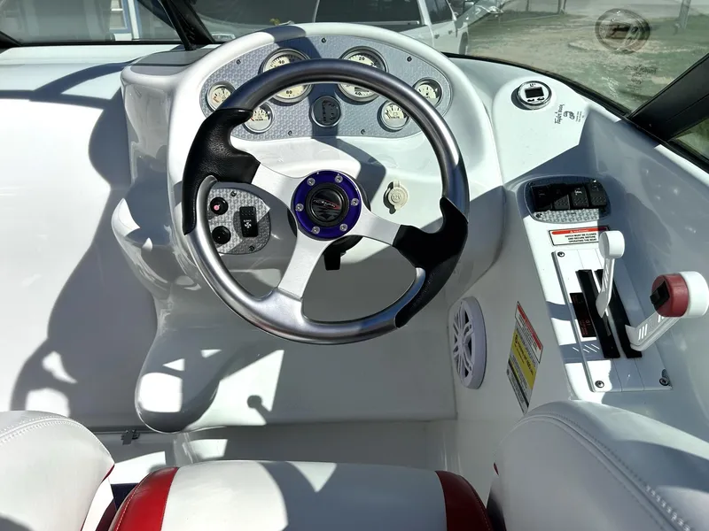 Slide: The Image of Steering wheel and controls of a 2002 Baja 232 boat cockpit. - 44