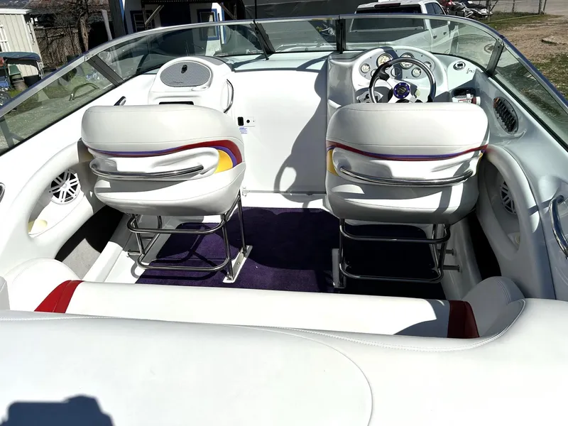 Slide: The Image of Interior of a 2002 Baja 232 boat with white seating and modern dashboard. - 7