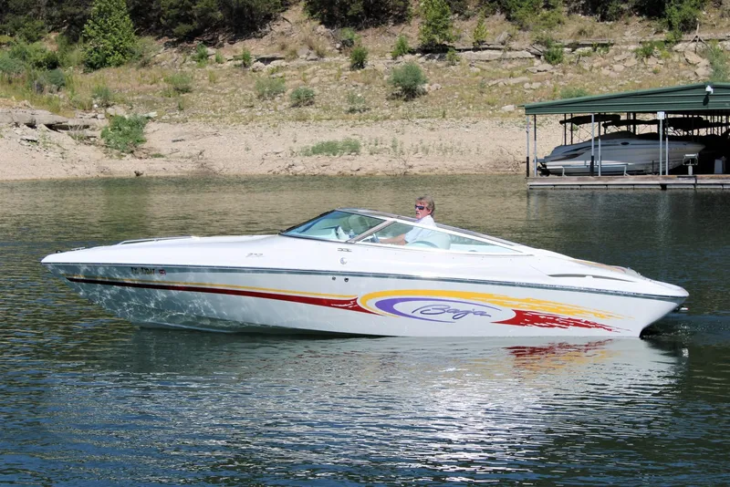 Slide: The Image of 2002 Baja 232 speedboat cruising on a lake near a dock. - 8