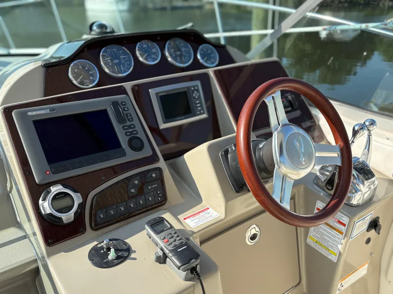 Slide: The Image of Helm of 2012 Sea Ray 350 Sundancer with wood steering wheel and navigation controls. - 11