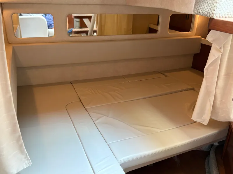 Slide: The Image of 2012 Sea Ray 350 Sundancer cabin interior with beige upholstery and mirrored accents. - 16
