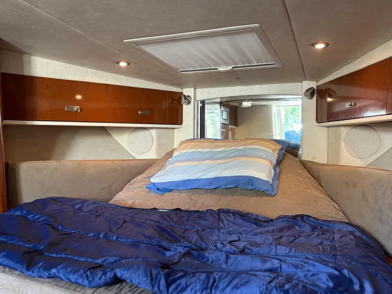 Slide: The Image of Interior cabin of 2012 Sea Ray 350 Sundancer with cozy bedding and wooden cabinets. - 17