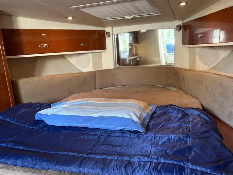 Slide: The Image of Interior cabin of 2012 Sea Ray 350 Sundancer with cozy bed and wooden cabinets. - 18